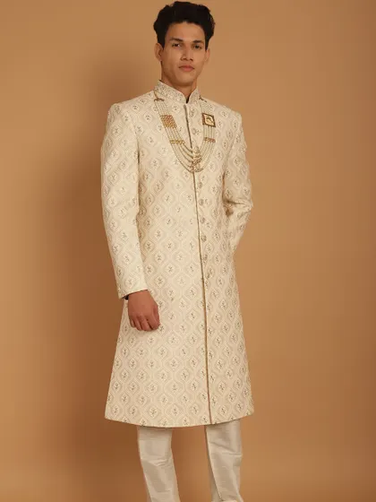 A full-length view of our geometric-patterned ivory sherwani, a modern take on a classic silhouette for the discerning groom.