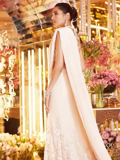 A vision in white. This shot captures the ethereal quality of the custom Tamara Ralph saree, with its flowing cape-like drape. It's a perfect example of modern couture.