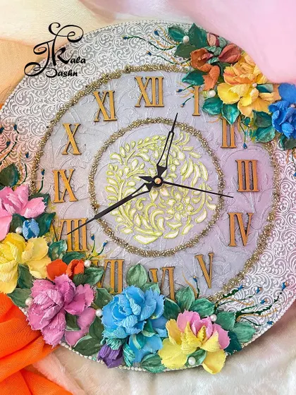 A beautiful 14-inch wall clock with a neutral grey base, golden Roman numerals, and a burst of colorful flowers.