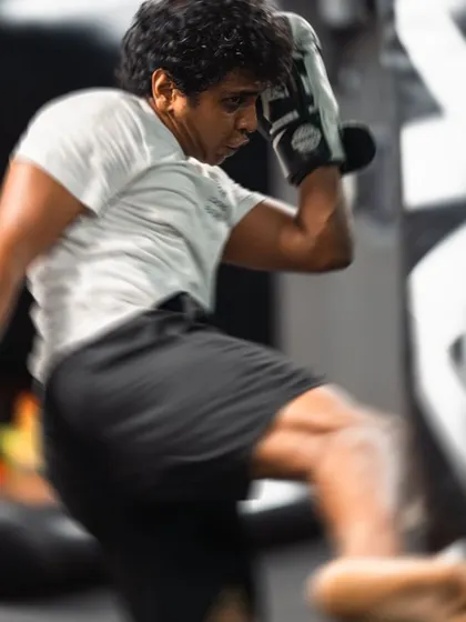Motion blur captures the speed and power of a roundhouse kick connecting with the heavy bag.