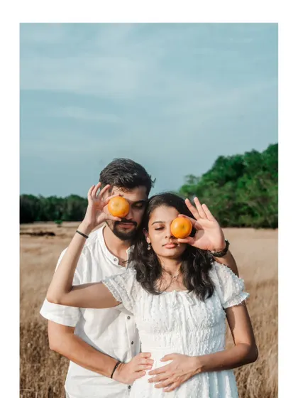 A fun and quirky pose with the couple holding oranges over their eyes, showing their playful side during a pre-wedding shoot.