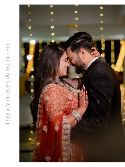 An intimate portrait of the couple with their foreheads touching, surrounded by the warm glow of fairy lights at their reception.
