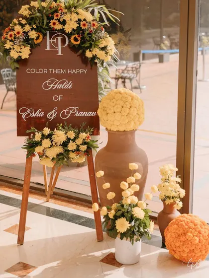 The welcome easel surrounded by terracotta pots and spheres of marigolds.