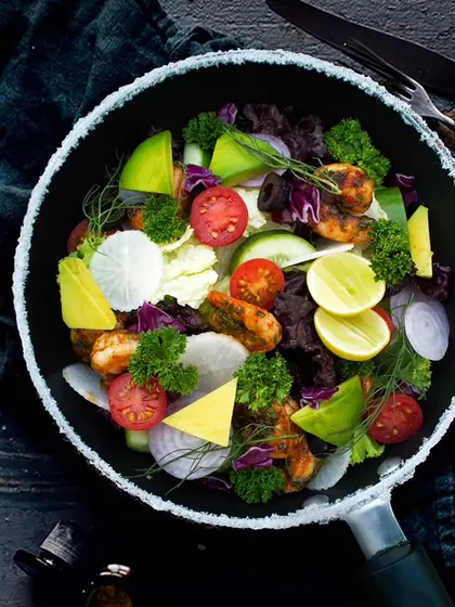 For a luxurious and healthy meal, try our Avocado Prawns Cocktail Salad. It's a beautiful combination of mixed greens, avocado, grilled prawns, and fresh veggies, perfect for a special treat.