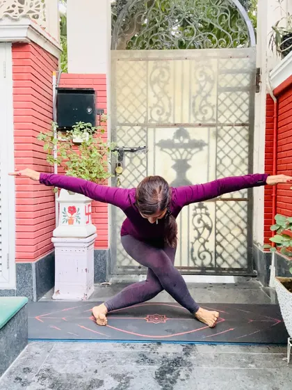 A revolved chair pose, or Parivrtta Utkatasana, is a deep twisting posture that detoxifies the body and strengthens the core and legs. For me, this pose represents the idea that stretching your body helps to stretch your mind, allowing happiness to flow.
