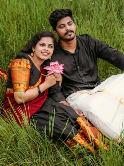 A sweet portrait of a couple sitting in a field, holding a lotus flower, a symbol of purity and beauty.