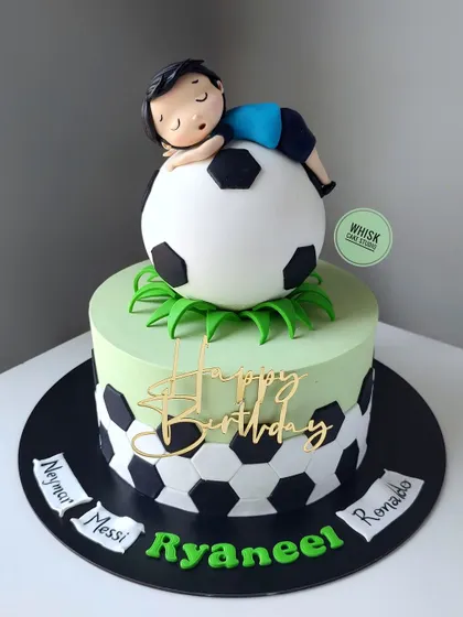 A cake for a boy who eats, sleeps, and dreams of football. This design features a handcrafted figurine of a boy sleeping on a giant, edible football.