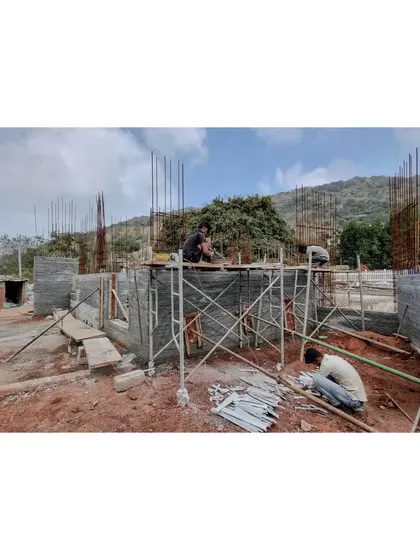 Workers assemble the composite stone walls on site at Nandi Hills. This building technique combines traditional masonry with modern engineering.