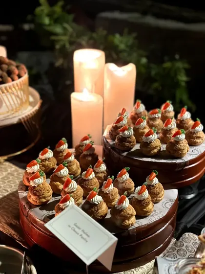 A close-up of the Gajar Halwa choux pastries, showing the detail of the tiny carrot garnish.