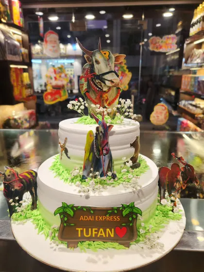 A unique two-tier cake designed to celebrate a bull race champion. This custom creation features detailed edible images of the prized bull, making it a truly personal centerpiece.