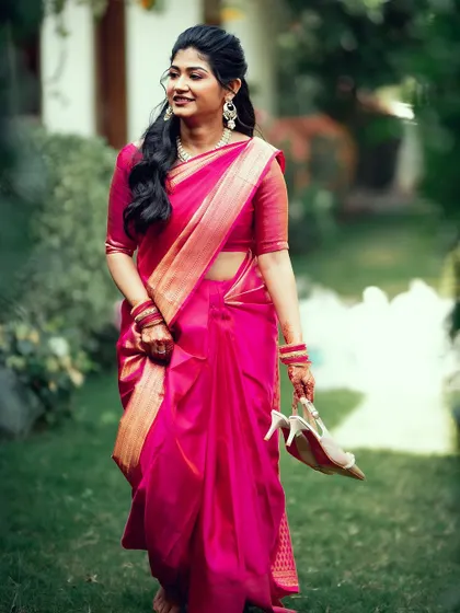 A candid shot of the bride walking barefoot on the grass, holding her heels, a moment of relaxed elegance.