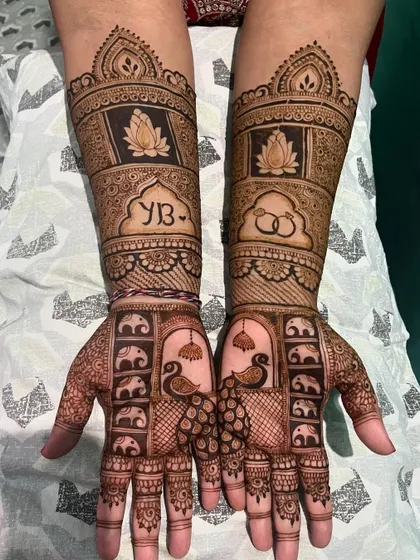 A unique design featuring peacocks and baby elephants on the palms, with the couple's initials and wedding rings incorporated on the arms.