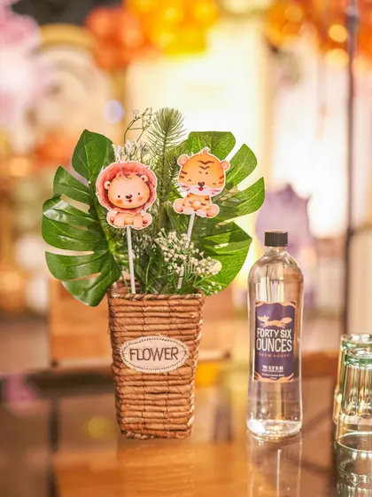 A small but charming detail from a jungle-themed party. Even the table centerpieces, with cute animal cutouts in a flower pot, are designed to match the overall aesthetic.