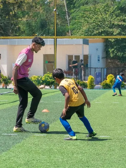 A coach engages with a player during a fun drill at the Annual Day. Even during celebrations, there are opportunities for learning and connection.