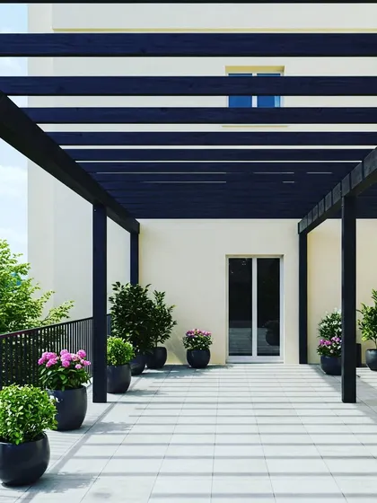 A long, black metal pergola creating a shaded walkway or gallery space on a large terrace. This design is perfect for connecting different parts of a building or for lining a rooftop with shaded seating.