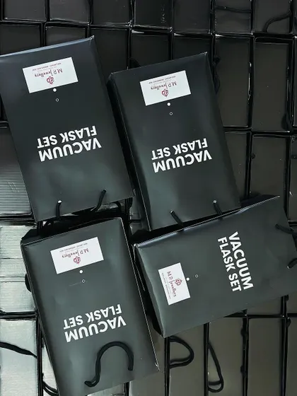 An overhead view of four branded gift bags, showing the consistent logo placement and quality we maintain across an entire bulk order.