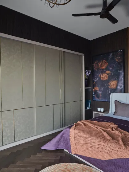 The leather-clad wardrobe shutters in the dark master bedroom, which exude elegance and complement the rich veneer and fluted panels.