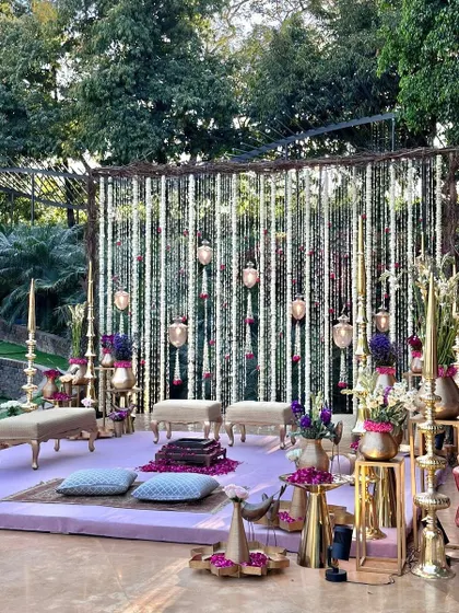 A frontal view of the lavender vedi, highlighting the symmetry and beauty of the floral backdrop and brass elements.