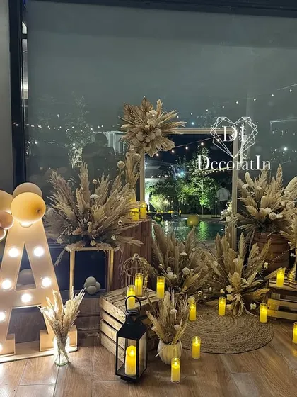 The rustic photo corner illuminated at night, with dozens of LED candles creating a warm and inviting glow.