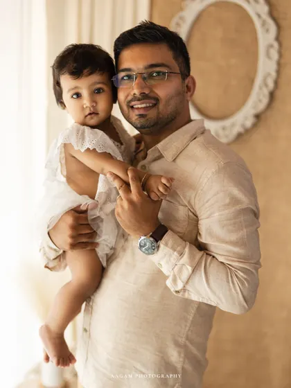 A sweet father-daughter portrait from a lifestyle session. His gentle hold and her curious gaze create a heartwarming and authentic moment.