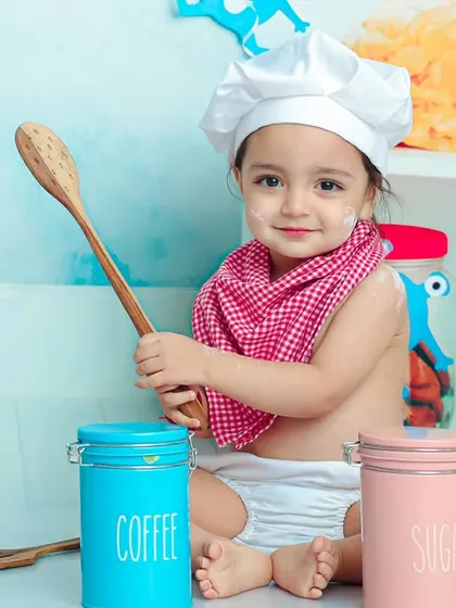A little bit of flour on the nose only adds to the charm. This little chef is enjoying a messy and fun-filled cooking adventure.