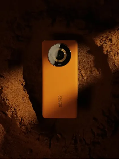 The Narzo phone on the sand set, with dramatic shadows creating a feeling of sunrise or sunset on another planet.