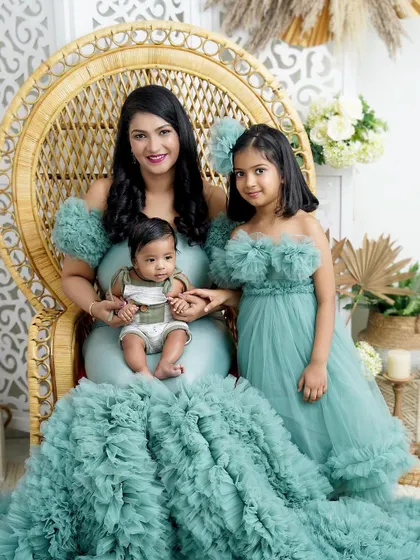 A mother and her two children, a portrait of grace. The older sister's poise and the baby's calm demeanor make this a truly special photograph.
