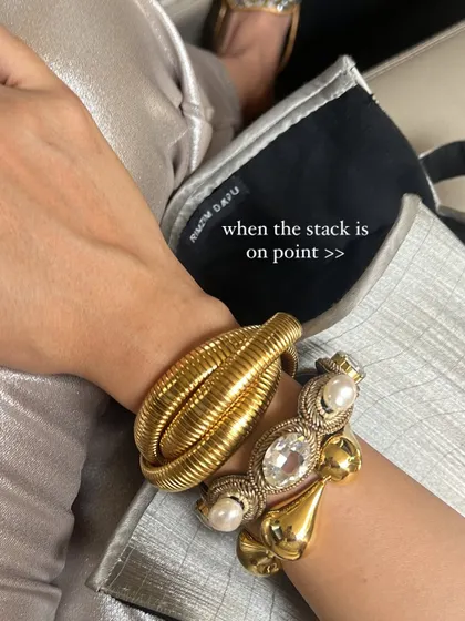 A close-up of a perfect arm stack. I love mixing different textures and metals, like this chunky gold bracelet paired with a vintage-style pearl and crystal cuff.