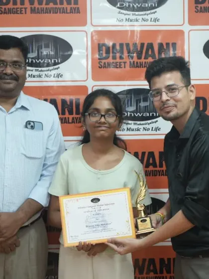 Two teachers present an award to their student.