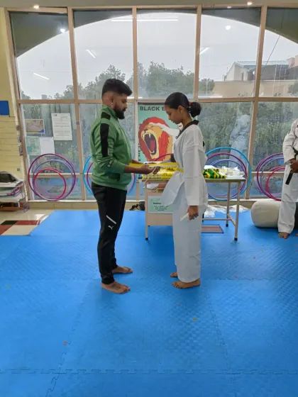 A student receives her yellow belt.