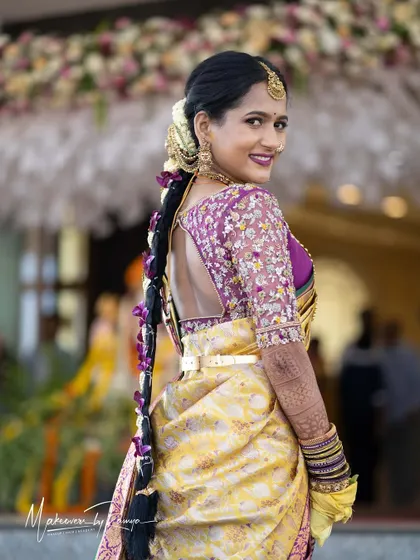 A back-profile shot of Jagruthi, showing off her long, traditional braid adorned with fresh flowers and her beautiful blouse design.
