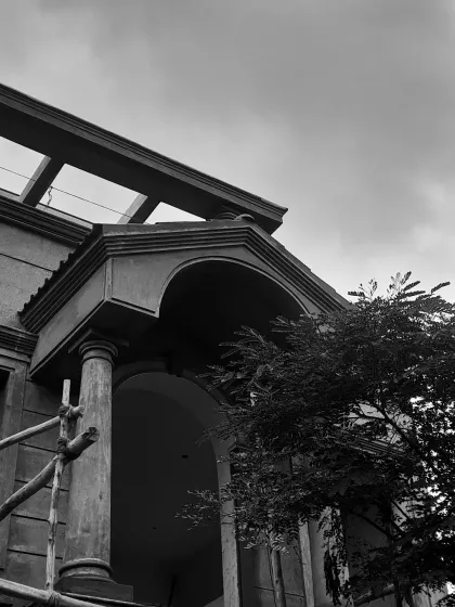 An under-construction view of a French-inspired balcony. This black and white shot highlights the intricate details, proportions, and symmetry that form the foundation of a well-crafted building elevation.