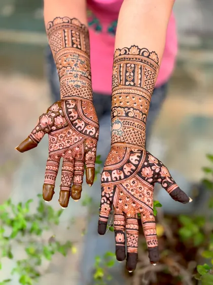 The back of the hands for a bridal design, featuring delicate elephant motifs.