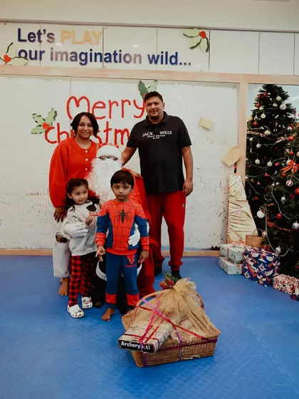 A family receives a gift basket from Santa during our Christmas celebration.