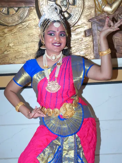 A classic Bharatanatyam pose, showcasing the dancer's control and grace. The mudra (hand gesture) is clearly and beautifully captured.