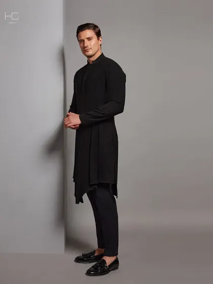 A side view of the bold, black asymmetrical kurta, highlighting its dramatic hemline and tailored fit. It's a piece designed for the man who isn't afraid to stand out.