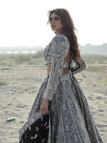 A side profile of the black and white lehenga, showing how the full-sleeve embroidered blouse complements the voluminous skirt.