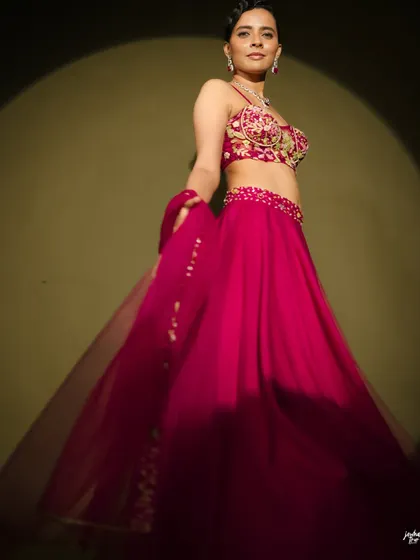 A dynamic shot capturing the movement of the lehenga. The makeup is designed to be flawless even in dramatic lighting, with a spotlight effect that highlights the model's features.