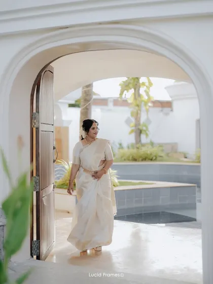 The bride makes her entrance through an elegant archway, captured in beautiful natural light.