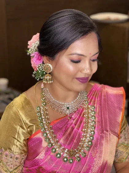 A beautiful, romantic updo adorned with fresh roses. The makeup is soft and glowing, with a pop of color on the lips to complete the look.