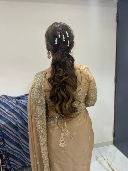 A wavy, textured ponytail with delicate pearl clips, creating a soft and romantic look for an evening event.