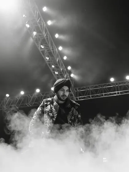 A dramatic, atmospheric shot of Gurdeep Mehndi on stage, enveloped in smoke. We use theatrical effects to create powerful visual moments that make for stunning photographs and lasting memories.