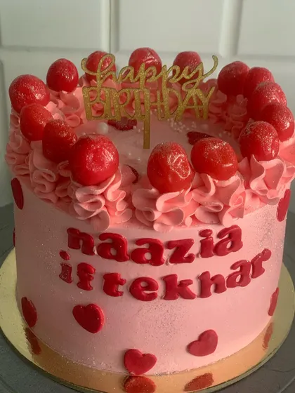 A sweet pink cake topped with cherries and decorated with little red hearts. A lovely choice for a birthday or just because.