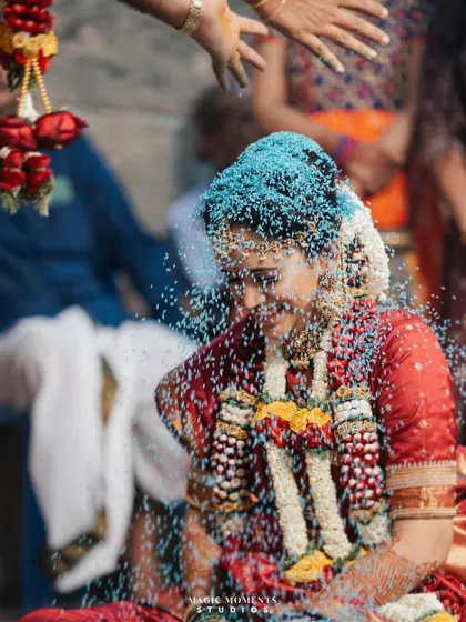 A beautiful companion shot to the groom's photo, this one captures the bride, Snigdha, being showered with blessed rice during the Akshata ritual.