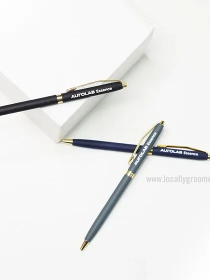 We produce high-quality custom pens perfect for corporate gifting. This image shows a set of elegant metal pens with gold accents, branded for Aurolab Essence.