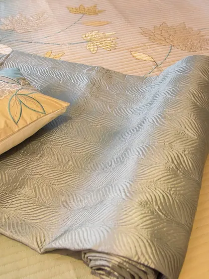 Feel the gentle caress of velvet and the serene charm of lotus embroidery. This close-up shows a rolled-up bed runner with a beautiful textured leaf pattern, part of my nature-inspired collection.