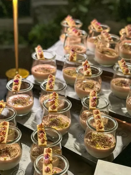 A beautiful display of Kalakand & Rose Mousse with Pistachio Crumble, served in individual glass jars. This was part of a dessert spread for an event in Hampi.