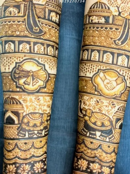 A close-up of the forearm details in a traditional bridal mehndi. This design includes symbols of the wedding ceremony, such as the gathbandhan (tying of the knot) and hastmelap (joining of hands).