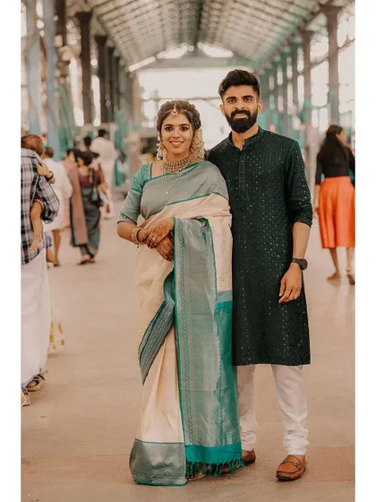 A classic full-length portrait of a couple in a temple corridor.