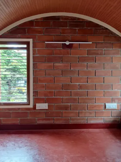 The simple, timeless form of a brick arch gives this room a sense of grace and stability. Paired with a red oxide floor and a vaulted ceiling of exposed brick, the space feels both ancient and modern.